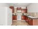 Well-lit kitchen featuring dark wood cabinets, tile floors, and modern appliances at 3085 Duneville St, Las Vegas, NV 89146