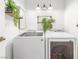 Well-lit laundry room with a front load washer and dryer, shelving, and neutral decor at 3085 Duneville St, Las Vegas, NV 89146