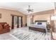Spacious main bedroom featuring a ceiling fan, cozy sitting area, and a large window at 3085 Duneville St, Las Vegas, NV 89146