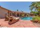 Beautiful backyard pool with patio furniture, stone accents, and a covered outdoor living space at 3085 Duneville St, Las Vegas, NV 89146