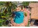 Aerial view of a backyard oasis with a sparkling blue pool, mature palms, and a cozy lounge area perfect for outdoor relaxation at 3085 Duneville St, Las Vegas, NV 89146
