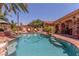 Swimming pool featuring a rock surround, lush landscaping, and a tanning shelf for relaxing at 3085 Duneville St, Las Vegas, NV 89146