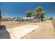 Gravel backyard with a concrete parking area and privacy fence, offering lots of potential at 3090 Westwind Rd, Las Vegas, NV 89146
