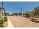 Sideyard view with gravel, storage shed, mature trees, and partial privacy fence at 3090 Westwind Rd, Las Vegas, NV 89146