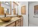 Bathroom featuring dual sinks, granite countertops, and wood cabinetry at 3090 Westwind Rd, Las Vegas, NV 89146