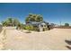 Exterior view of home showing the gravel backyard, mature trees, and well-maintained landscaping at 3090 Westwind Rd, Las Vegas, NV 89146
