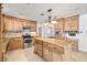 Bright eat-in kitchen features a central island, stainless steel appliances, and wooden cabinetry at 3090 Westwind Rd, Las Vegas, NV 89146