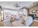 Bright, open-concept living room featuring a modern ceiling fan, plush sectional sofa, and an adjacent sitting area at 3101 Hayden Ct, Las Vegas, NV 89134