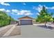 The home features a large driveway, mature landscaping, and a two-car garage at 317 Kane Ave, Las Vegas, NV 89110
