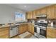 Well-lit kitchen featuring wood cabinets, stainless steel appliances, and a modern backsplash at 317 Kane Ave, Las Vegas, NV 89110