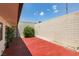 Spacious, private backyard with a vibrant red concrete patio and a textured block wall at 3785 Decade St, Las Vegas, NV 89121