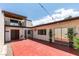 Wide-angle shot of backyard featuring a red patio, exterior doors and upper level balcony at 3785 Decade St, Las Vegas, NV 89121