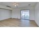 Bright bedroom with wood-look flooring, sliding glass door, and ceiling fan at 3785 Decade St, Las Vegas, NV 89121