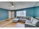 Comfortable living room with wood floors, modern lighting, and plush sofa with accent pillows near door at 3785 Decade St, Las Vegas, NV 89121
