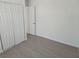 Bright, airy bedroom showcasing wood-look floors, closet, and white walls at 3911 Torsby Pl, Las Vegas, NV 89119