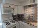 Close-up of the kitchen features white cabinetry, modern countertops, and stainless steel appliances at 3911 Torsby Pl, Las Vegas, NV 89119