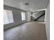 Open-concept living room with tile flooring and natural light from windows, features stairs at 3911 Torsby Pl, Las Vegas, NV 89119
