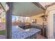 Covered outdoor kitchen featuring stone accents, a granite countertop, and a built-in grill at 433 Jubilation Dr, Las Vegas, NV 89145