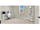 Bedroom with carpeted floors, a large window, and a modern white shelving unit against a light grey wall at 4533 Queens Hill St, North Las Vegas, NV 89031