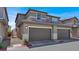 Attractive two-story townhome featuring attached two-car garage, neutral stucco, and well-kept landscaping at 4533 Queens Hill St, North Las Vegas, NV 89031