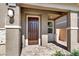 A covered entryway with stone columns, a dark wood door and a brick pathway at 4533 Queens Hill St, North Las Vegas, NV 89031