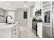 A modern kitchen with white cabinets, stainless steel appliances, and a large island at 4533 Queens Hill St, North Las Vegas, NV 89031