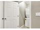Small, compact laundry room with a stacked washer and dryer next to a white door at 4533 Queens Hill St, North Las Vegas, NV 89031