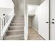 Carpeted stairs with white railing next to a storage area with a white door at 4533 Queens Hill St, North Las Vegas, NV 89031