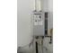Close-up of a tankless water heater installed on a white wall with visible connections at 4533 Queens Hill St, North Las Vegas, NV 89031