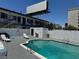 Swimming pool with clear water and white lounge chairs, enclosed by a textured white wall and featuring an adjacent building at 4600 Paradise Rd # 16, Las Vegas, NV 89169
