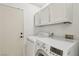 Functional laundry area featuring white appliances and cabinetry at 4753 Carefree Dr, Las Vegas, NV 89122