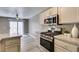 Well-lit kitchen boasts granite countertops, stainless steel appliances, and gray wood-look flooring at 507 Satin Saddle Pl, Henderson, NV 89052