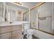Bathroom featuring sink, toilet, tub with sliding glass doors, and neutral tile at 5139 Zapata Ln, North Las Vegas, NV 89031
