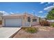 Exterior view of a well-maintained home with a tile roof, low-maintenance landscaping, and an attached garage at 5139 Zapata Ln, North Las Vegas, NV 89031
