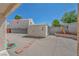 A wooden shed sits on gravel with brick steps, complemented by a wall and some greenery at 5139 Zapata Ln, North Las Vegas, NV 89031