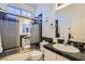 This bathroom features a shower with glass doors, a toilet, and a sink with black tile at 5409 Flora Spray St, Las Vegas, NV 89130