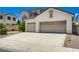 A stucco home with a gray tile roof and a spacious driveway at 5409 Flora Spray St, Las Vegas, NV 89130