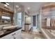 Modern bathroom with dual vanities, sleek fixtures, a walk-in shower, and a luxurious soaking tub at 5438 Sierra Brook Ct, Las Vegas, NV 89149