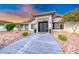 Charming home featuring a modern double-door entrance, desert landscape, and a well-maintained lawn at 5438 Sierra Brook Ct, Las Vegas, NV 89149