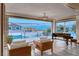 Bright living room featuring modern decor, a piano, and expansive views of the outdoor pool and neighborhood at 5438 Sierra Brook Ct, Las Vegas, NV 89149