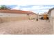 Wide angle view of a low maintenance backyard area covered in decorative stones and surrounded by a white fence at 5733 Dazzling Sparks St, North Las Vegas, NV 89031
