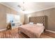 Bright bedroom with a large, tufted headboard, wood floors, and a decorative chandelier at 5733 Dazzling Sparks St, North Las Vegas, NV 89031