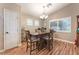 Bright dining room featuring a dark wood table, plantation shutters, and hardwood floors at 5733 Dazzling Sparks St, North Las Vegas, NV 89031