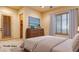 Virtually staged bedroom featuring a comfortable bed, a dresser with a TV, and window shutters at 6120 Kings Brook Ct, Las Vegas, NV 89149