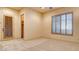 Bedroom featuring carpet floors, neutral walls, shutters on window and exterior door at 6120 Kings Brook Ct, Las Vegas, NV 89149