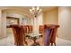 Formal dining room with stylish chandelier, plush seating and glass-topped table at 6120 Kings Brook Ct, Las Vegas, NV 89149