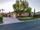 Charming exterior view showcasing the brick facade, mature trees, and three-car garage at 6120 Kings Brook Ct, Las Vegas, NV 89149