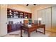 Bright home office featuring custom wood shelving, ample desk space, and natural light at 6120 Kings Brook Ct, Las Vegas, NV 89149