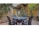 Inviting outdoor patio area with stone walls, climbing plants, and wrought-iron chairs at 6120 Kings Brook Ct, Las Vegas, NV 89149