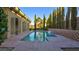Backyard pool area featuring mature trees and covered patio at 6120 Kings Brook Ct, Las Vegas, NV 89149